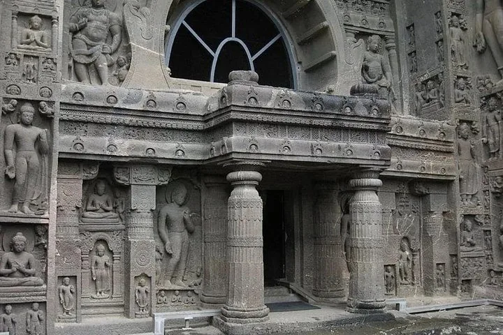 Kunstvoll verzierter Eingang mit Säulen und Reliefskulpturen in den Ajanta-Höhlen.