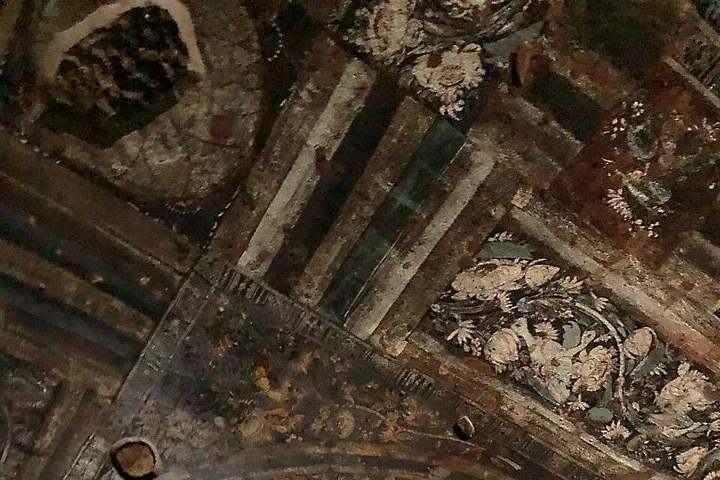 Détail de fresques anciennes de plafond montrant des motifs floraux et géométriques aux grottes d'Ajanta.