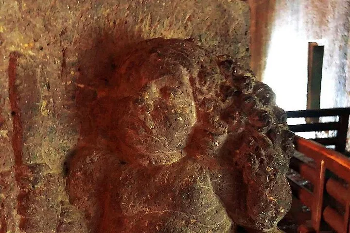 Sculpture en pierre altérée d'une figure, probablement une divinité ou un être céleste, aux grottes d'Ajanta.