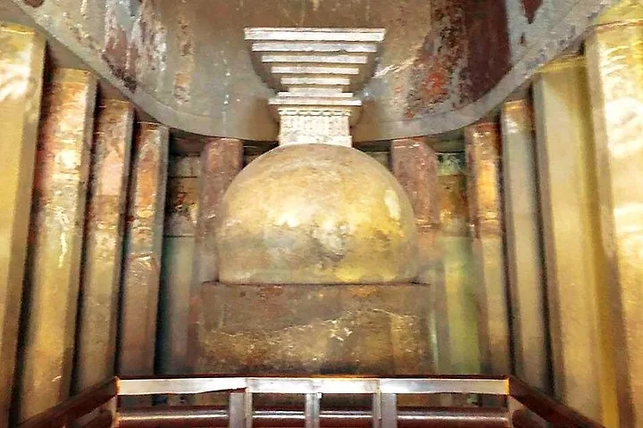 Un grand stupa en pierre à l'intérieur d'une grotte, entouré de piliers aux grottes d'Ajanta.