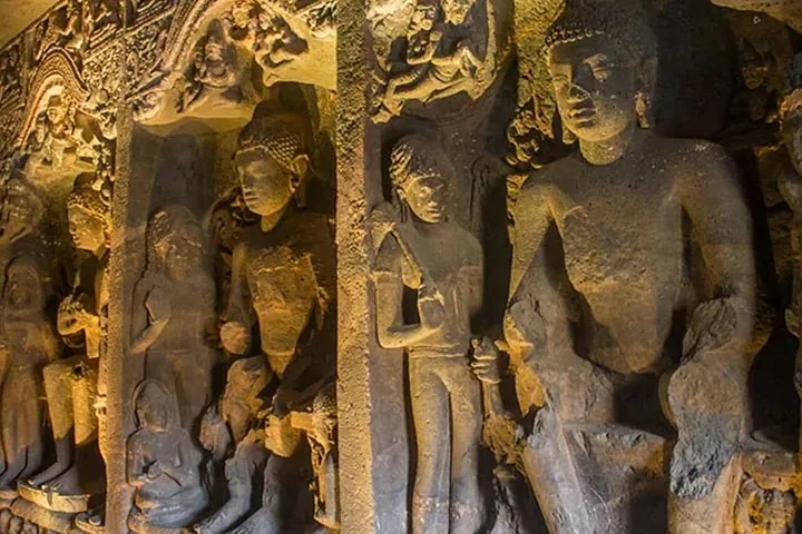 Rangée de grandes sculptures détaillées en pierre de Bouddha et d'autres personnages aux grottes d'Ajanta.
